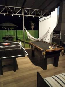 a room with a pool table and a hammock at casa com bela vista em itatiba in Bragança Paulista
