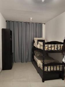 a room with three bunk beds and a curtain at casa com bela vista em itatiba in Bragança Paulista