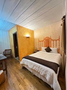 a bedroom with a large bed with a wooden headboard at NASS Casa del Aguila in Cuenca