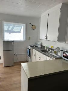 a kitchen with white cabinets and a counter top at Avon Apartments in Hamilton