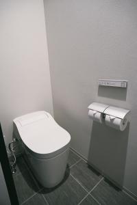 La salle de bains est pourvue de toilettes et de 2 rouleaux de papier toilette. dans l'établissement NEW HUMBER, 