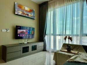 een woonkamer met een tv en een groot raam bij Greenfield Residence Sunway Subang 10 Pax 3R2B with Internet in Petaling Jaya