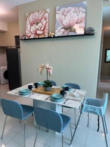 een eettafel met blauwe stoelen en bloemen erop bij Greenfield Residence Sunway Subang 10 Pax 3R2B with Internet in Petaling Jaya