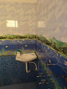 a bathroom with a sink and a mural of a river at Thirunallar Heaven Homes in Thirunallar