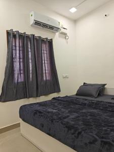 a bedroom with a bed and a air conditioner at Thirunallar Heaven Homes in Tirunallār