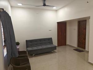 a living room with a couch and a door at Thirunallar Heaven Homes in Tirunallār