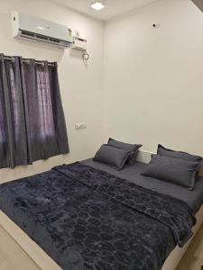 a bedroom with a large bed with black sheets at Thirunallar Heaven Homes in Tirunallār