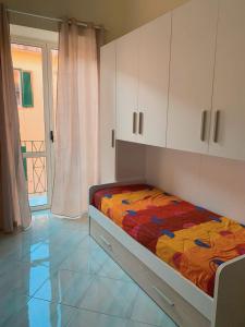 a bedroom with a bed with a colorful comforter at Casetta Sofia in Pozzuoli