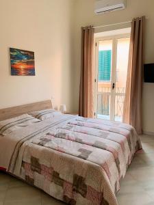 a bedroom with a bed and a large window at Casetta Sofia in Pozzuoli