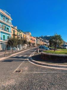 una calle urbana vacía con palmeras y edificios en Casetta Sofia, en Pozzuoli