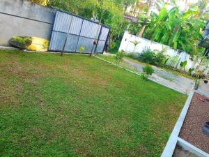 un patio con una valla y césped en Kabalana Ocean Blue, en Ahangama