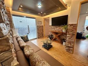a living room with a couch and a flat screen tv at Yllib Transient Condo in Baguio
