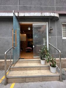 an open door to a building with two potted plants at Yllib Transient Condo in Baguio