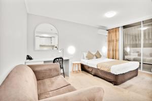 ein Hotelzimmer mit einem Bett und einem Sofa in der Unterkunft Carlton Lygon Lodge - Close to Melbourne Uni in Melbourne