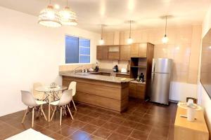 a kitchen with a refrigerator and a table and chairs at Alojamiento con Aire Acondicionado céntrico en Puyo in Puyo