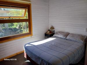 1 dormitorio con cama y ventana en Antares en Villa La Angostura