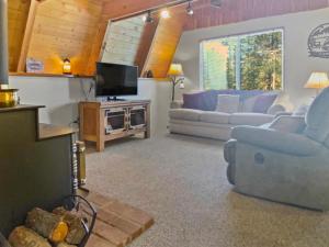 een woonkamer met 2 banken en een tv bij Fireside Cottage in Duck Creek Village