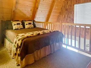 een slaapkamer met een bed in een blokhut bij Fireside Cottage in Duck Creek Village