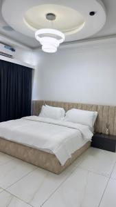 a bedroom with a large white bed in a room at Bash luxury apartments in Freetown