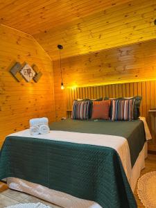 a bedroom with two beds in a log cabin at Chalés Canto da Serra in Monte Verde