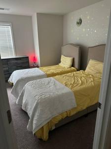 a bedroom with two beds with white and yellow sheets at Tranquil Graniteville Hideaway- Greater CSRA Area in Aiken