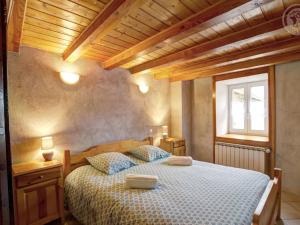 a bedroom with a large bed with a wooden ceiling at Gîte Saint-Bonnet-le-Courreau, 4 pièces, 8 personnes - FR-1-496-28 in Saint-Bonnet-le-Courreau