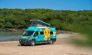 a blue van is parked on the beach at Van Del Sol - Stay where it moves you with Sunny in San Juan