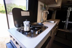 a kitchen with a sink and a pot on a stove at Van Del Sol - Stay where it moves you with Sunny in San Juan