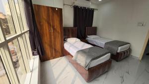 2 camas en una habitación con ventana en 1BH with Pantry, en Hyderabad