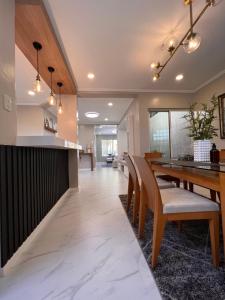 a dining room and kitchen with a wooden table and chairs at Bonel Townhouse Tagaytay in Alfonso