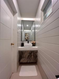 ein Badezimmer mit Waschbecken und Spiegel in der Unterkunft Bonel Townhouse Tagaytay in Alfonso + 23 Fotos
