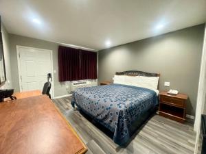 a hotel room with a bed and a table at Villa Court Inn Oroville in Oroville