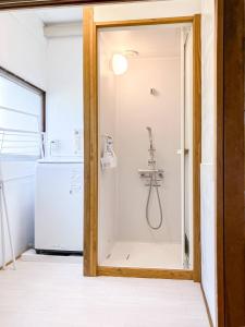 um chuveiro numa cozinha ao lado de um frigorífico em かぐら庵 em Kitakata