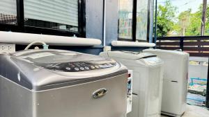 eine Reihe von Maschinen in einem Raum mit Fenstern in der Unterkunft FRIENDS@SaiLom in Bangkok + 21 Fotos