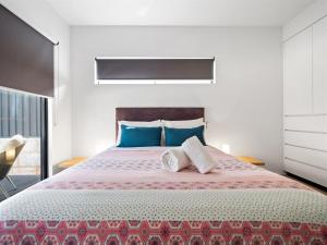 a bedroom with a large bed with two pillows at Tall Trees Margaret River in Margaret River Town