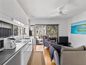 a kitchen with a couch and chairs in a room at Tall Trees Margaret River in Margaret River Town