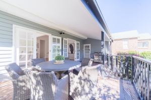 a patio with a table and chairs on a deck at La Villette sleeps 9 fireplace BBQ Pet Friendly in Katoomba