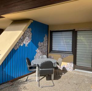 a room with a table and chairs in front of a wall at Mira in Gernsbach
