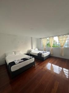 2 camas num quarto com pisos e janelas em madeira em Travesía Quindiana em Filandia