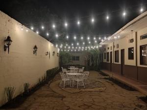 un patio con mesa, sillas y luces en Hotel Sansivar, en El Venado