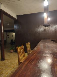 Hotel Sansivar في El Venado: وجود طاولة وكراسي خشبية كبيرة في الغرفة