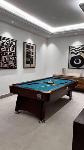 a pool table in a room with paintings on the wall at شقة خاصة فاخرة + صالة بلياردو in Riyadh