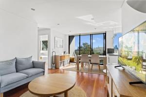 a living room with a couch and a table at Prime Location 2-Bed Apartment with Parking in Sydney