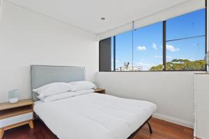 En eller flere senge i et værelse på Prime Location 2-Bed Apartment with Parking