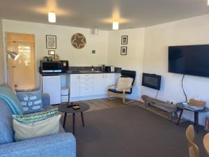 a living room with a couch and a flat screen tv at Glenorchy Retreat Apartment in Glenorchy