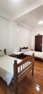 1 dormitorio con 2 camas y suelo de madera en Cool Breeze Lodge and Cafe, en Banaue