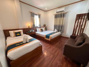 ein Hotelzimmer mit 2 Betten und einem Sofa in der Unterkunft Mahasok hotel in Luang Prabang
