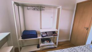 Cette chambre comprend une étagère avec un miroir et un lit. dans l'établissement Cantinho Sol & Mar Pé na Areia frente ao Mar com churrasqueira na sacada e piscina, à Praia Grande