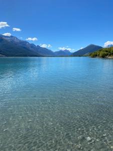 ein großer Wasserkörper mit Bergen im Hintergrund in der Unterkunft Glenorchy Retreat Apartment in Glenorchy