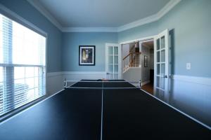 a living room with blue walls and a large window at Big 5 Bdrm Private Hot Tub Pool Table Near Shops in Loganville